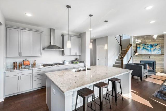 4331 Little Leaf Road Naperville, IL 60564 - Photo 4 of 39 a kitchen with stainless steel appliances granite countertop a stove a sink a kitchen island with wooden cabinets and wooden floor