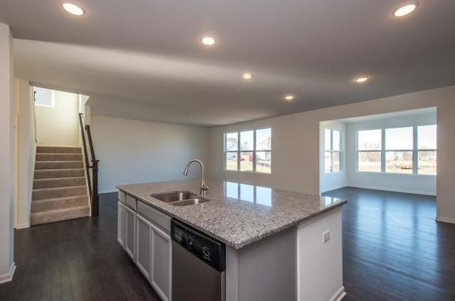 4331 Little Leaf Road Naperville, IL 60564 - Photo 9 of 39 a kitchen with stainless steel appliances granite countertop a sink stove and wooden floor