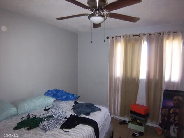 a bedroom with a bed and a chandelier fan