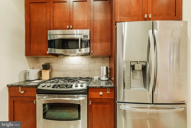 a kitchen with stainless steel appliances wooden cabinets and a stove