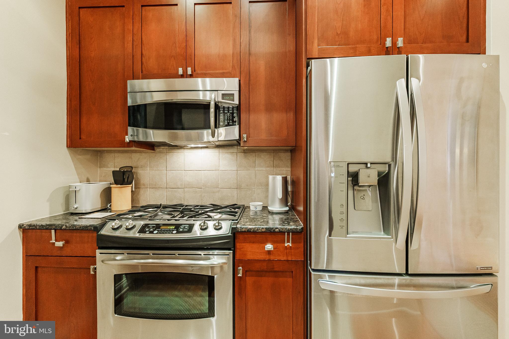 2049 Walnut Street, Unit 1R Philadelphia, PA 19103 - Photo 11 of 20 a kitchen with stainless steel appliances wooden cabinets and a stove