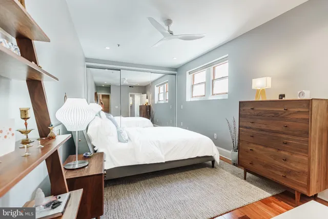 a bedroom with a bed and a flat tv screen on dresser