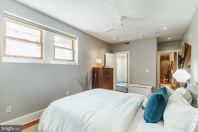 a bedroom with a bed and dresser with mirror