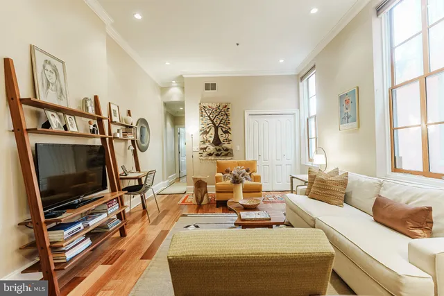 a living room with furniture a flat screen tv and a window
