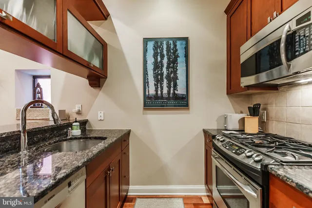 a kitchen with granite countertop a sink stove and cabinets