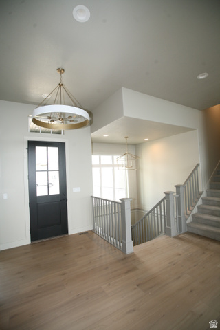635 East Mountain Road North Ogden, UT 84414 - Photo 18 of 33 Entryway featuring wood-finish flooring, a dark-paneled front door with divided lites, and a chandelier with a gold-tone frame and white drum shade