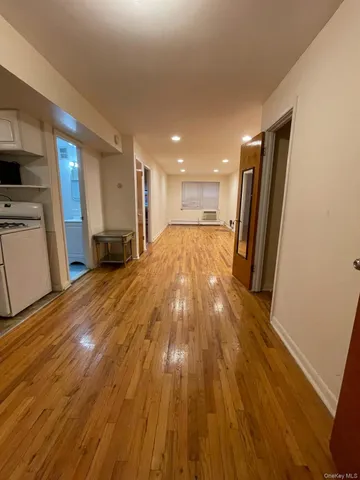 a view of empty room with wooden floor and electronic appliances