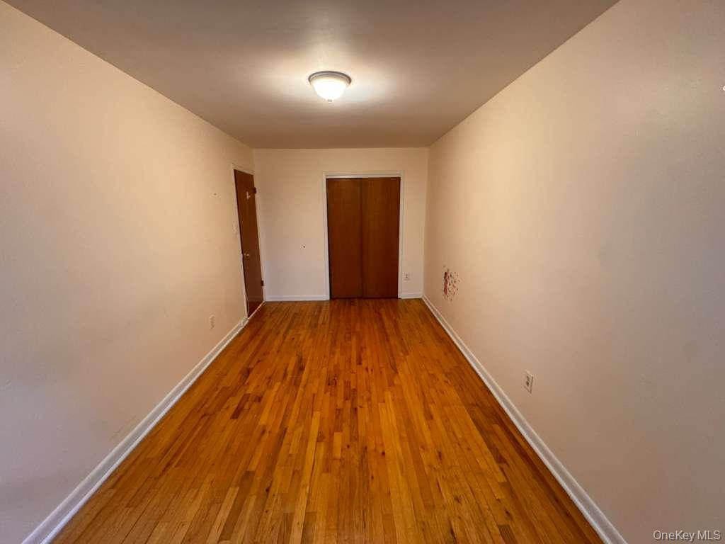 Undisclosed Address Queens, NY 11415 - Photo 2 of 3 wooden floor in a hall with a window