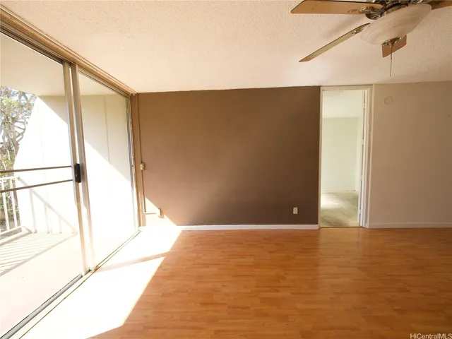 a view of a big room with wooden floor and windows