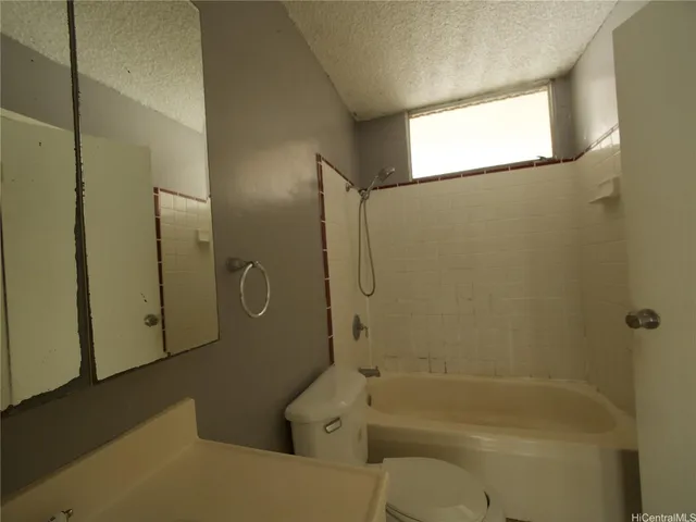 a bathroom with a tub a toilet and a shower