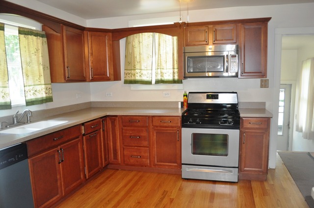 456 Franklin Boulevard Elgin, IL 60120 - Photo 4 of 14 a kitchen with stainless steel appliances wooden cabinets and a stove top oven