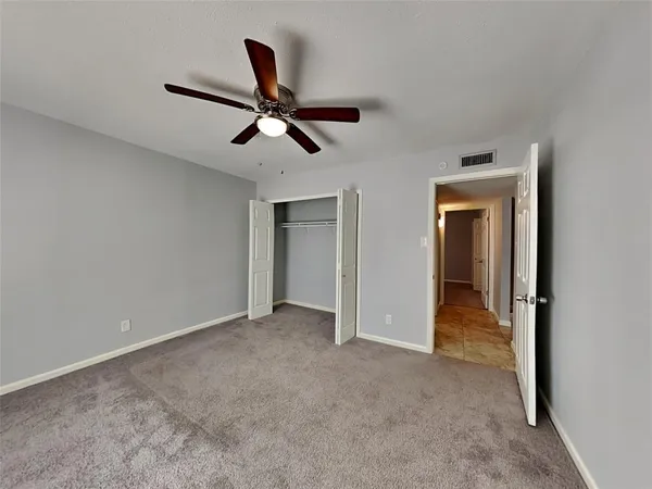 a view of empty room with ceiling fan
