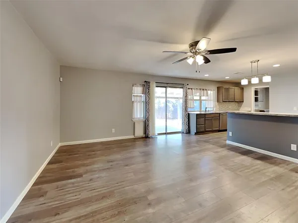 a view of an empty room with a kitchen counter space and a window