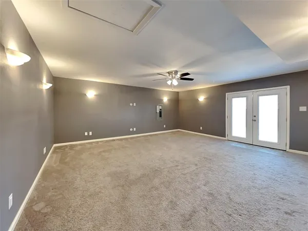 an empty room with windows and ceiling fan