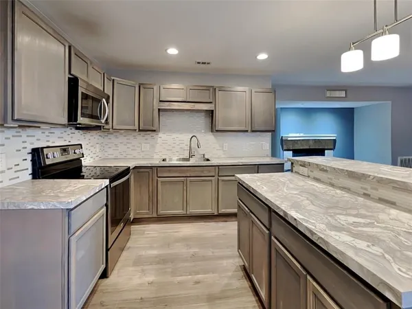 a kitchen with stainless steel appliances granite countertop a sink stove microwave and cabinets