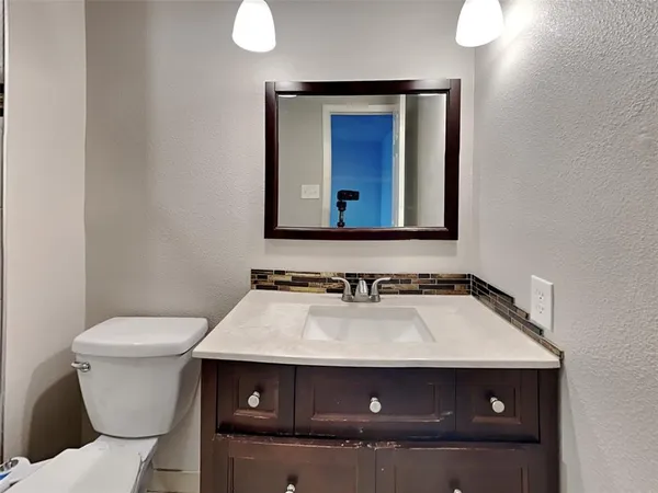a bathroom with a toilet sink and mirror
