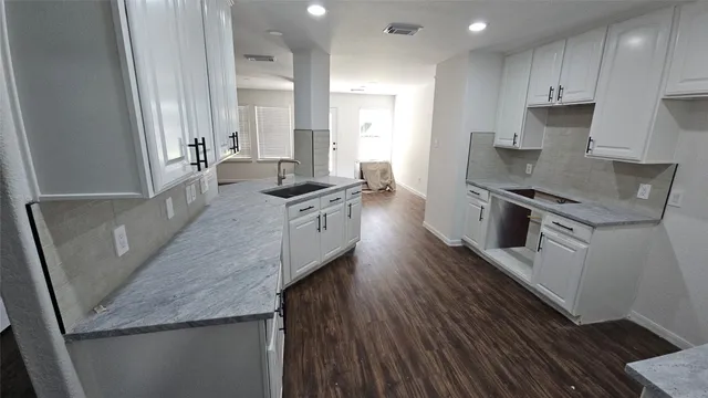 a large kitchen with stainless steel appliances granite countertop a lot of counter space and wooden floors