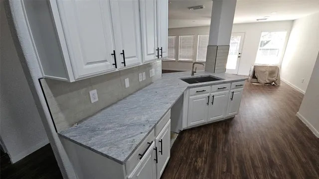 a kitchen with stainless steel appliances granite countertop a sink stove and wooden floor