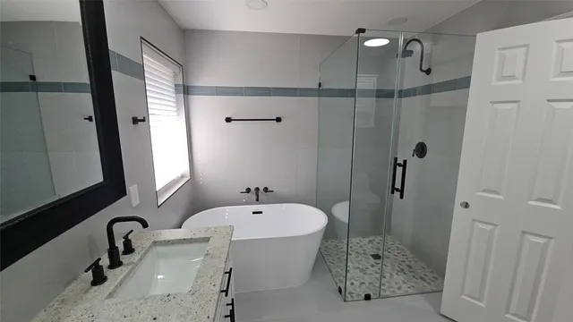 a bathroom with a tub sink and mirror