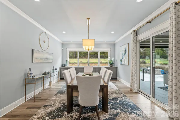 a dining room with furniture a chandelier and wooden floor