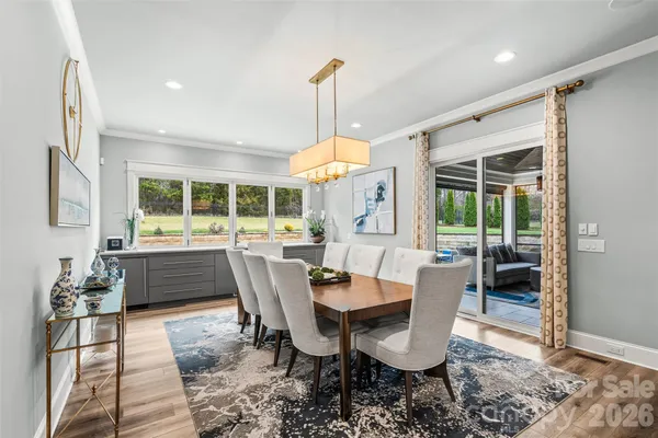 a dining room with furniture a chandelier and wooden floor