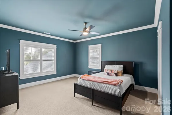 a bedroom with a large bed and a chandelier