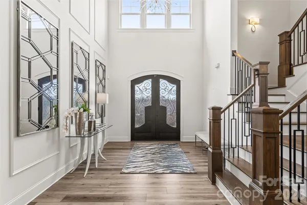 a view of a hallway with wooden floor and staircase