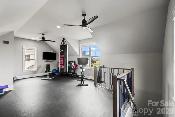 a view of a livingroom with wooden floor and a ceiling fan