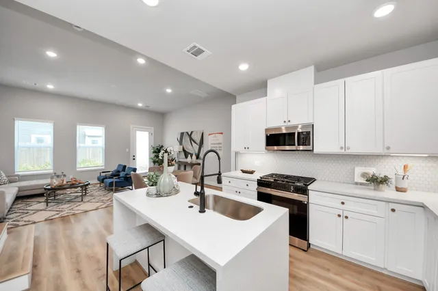 a kitchen with counter top space a sink stainless steel appliances and cabinets