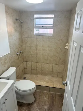 a bathroom with a toilet a sink and shower
