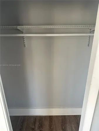 a view of a closet with wooden floor