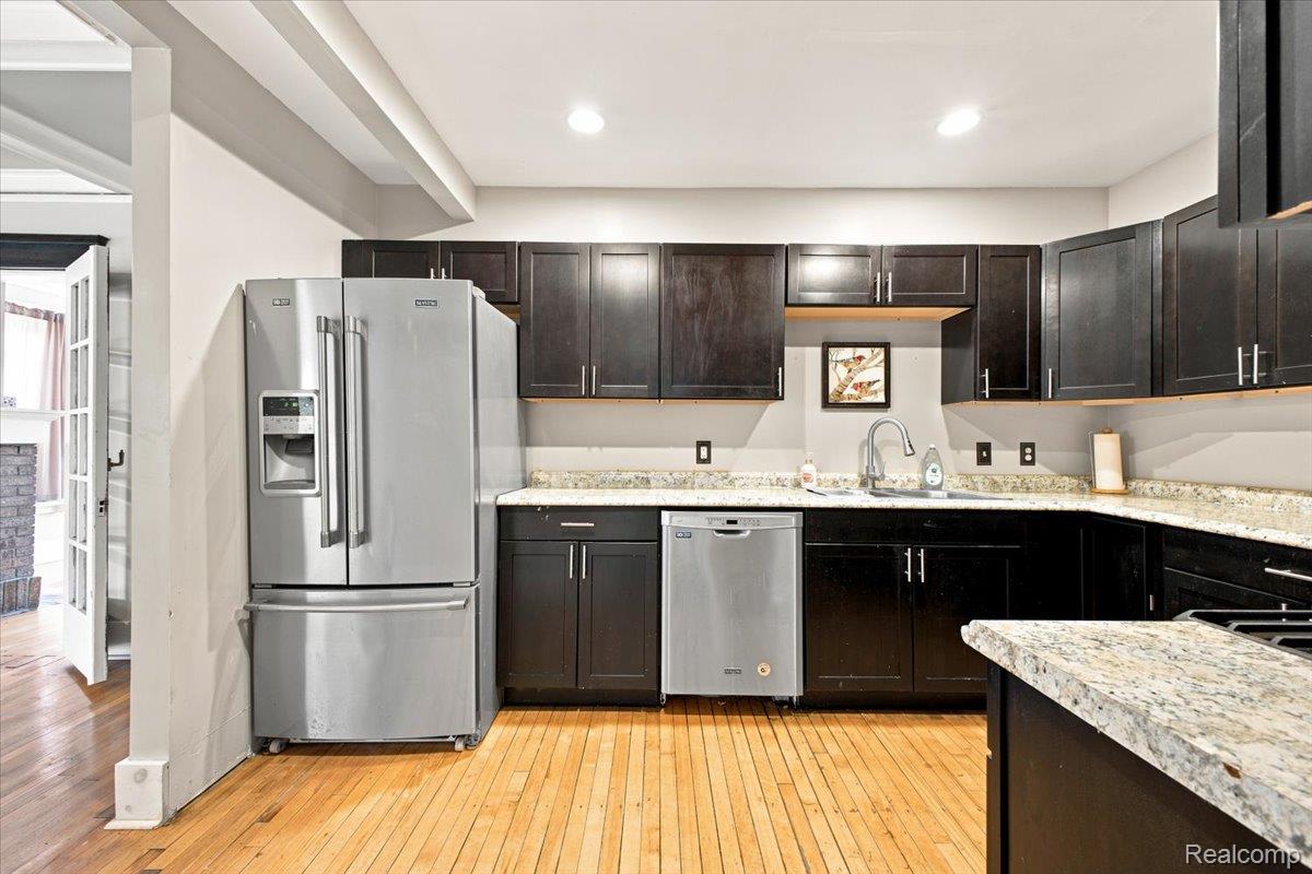 899 Edison Street Detroit, MI 48202 - Photo 12 of 37 Kitchen featuring dark wood cabinetry, light-toned countertops, stainless steel appliances, and wood-finish flooring