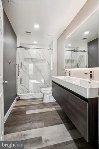 a bathroom with a double vanity sink a mirror and a shower