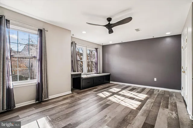a bedroom with window ceiling fan and wooden floor