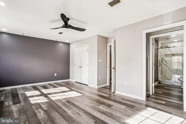 a view of a livingroom with a ceiling fan and wooden floor
