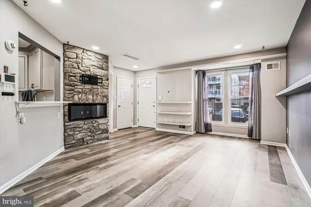 a view of an empty room with a fireplace and cabinet