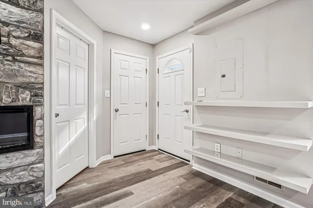 a view of a livingroom with wooden floor and a fireplace