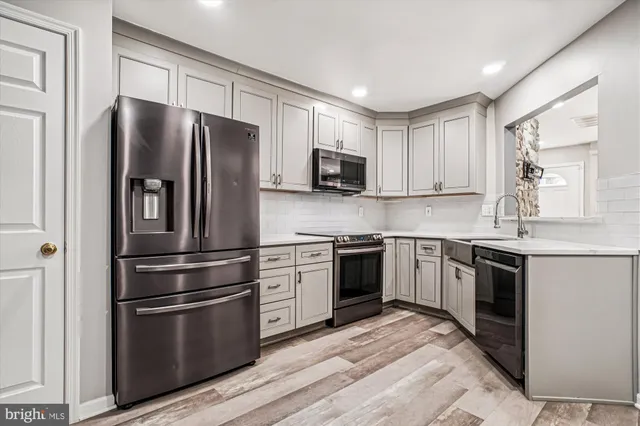 a kitchen with stainless steel appliances granite countertop a refrigerator stove and sink