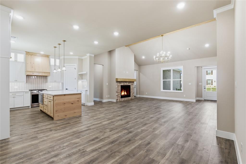 709 Anne Road Van Alstyne, TX 75495 - Photo 6 of 28 Spacious open-concept living area featuring wood-finish flooring and vaulted ceilings