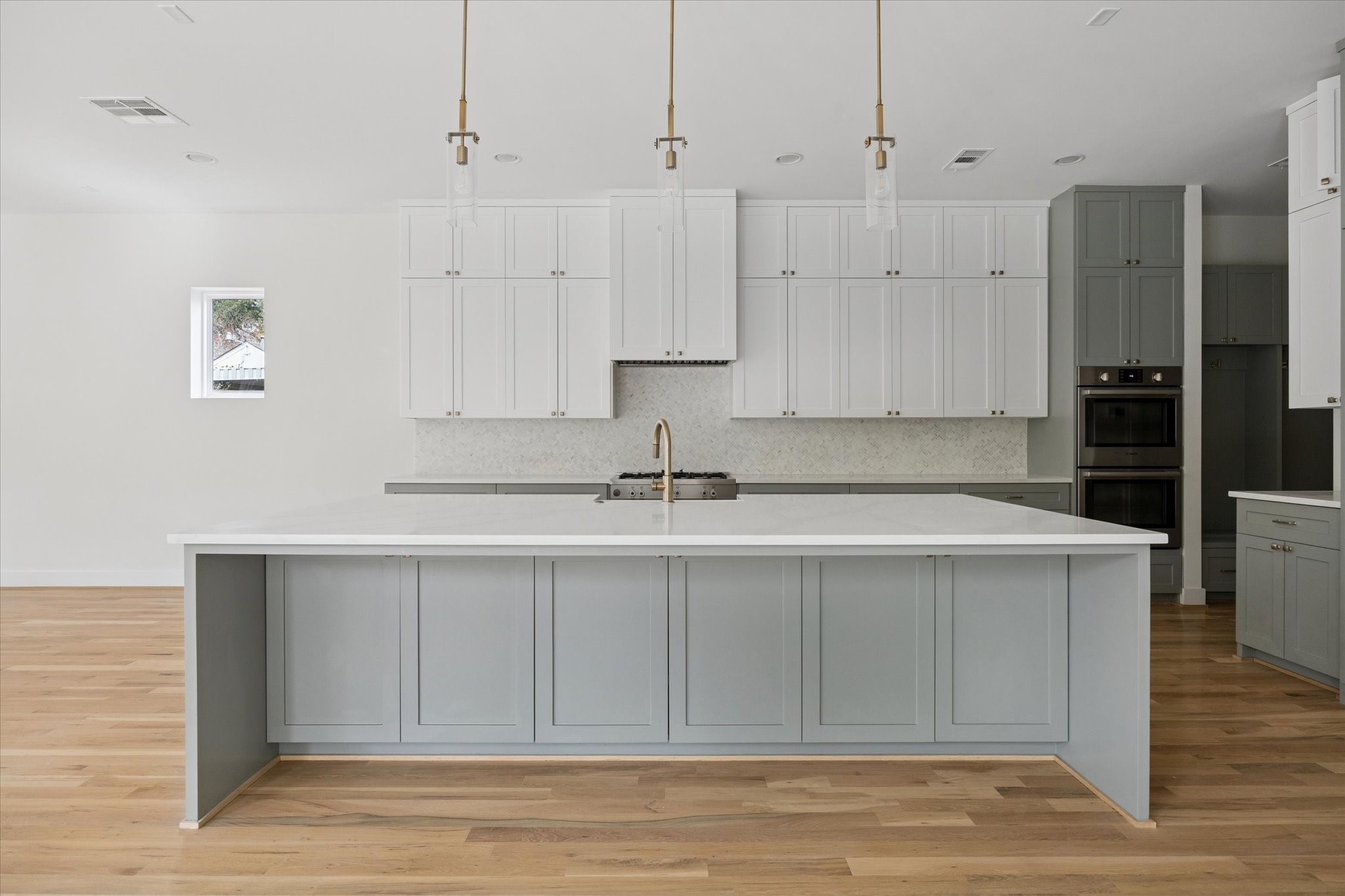 4219 Alba Road Houston, TX 77018 - Photo 7 of 37 Oversized kitchen island with quartz countertops, custom cabinetry, and designer pendant lighting—ideal for entertaining and everyday use.