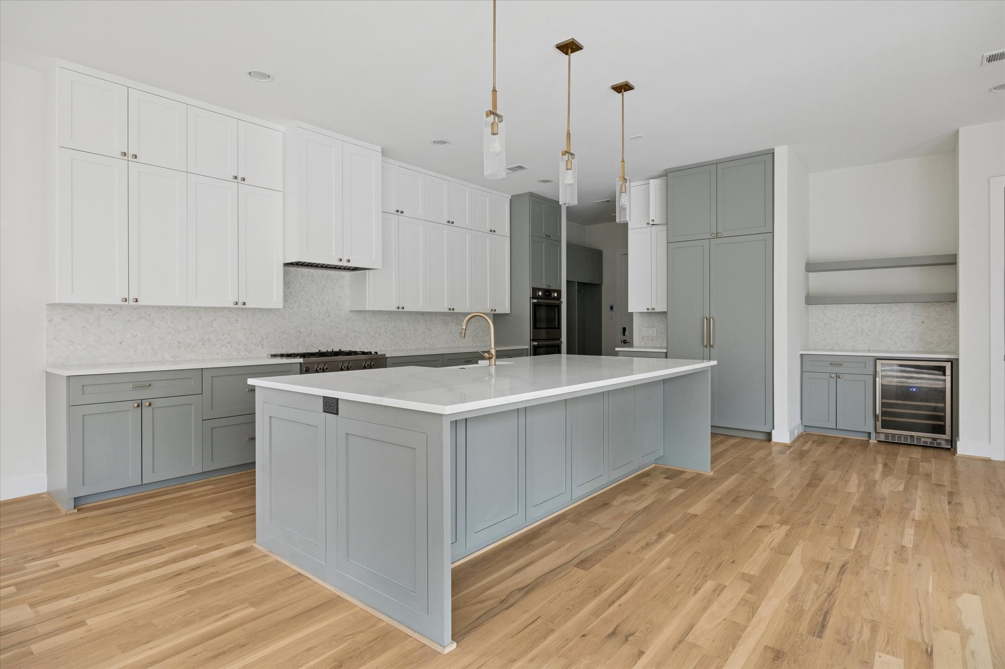 4219 Alba Road Houston, TX 77018 - Photo 8 of 37 Chef’s kitchen featuring custom two-tone cabinetry, large center island, premium finishes, and seamless flow to adjacent living spaces.