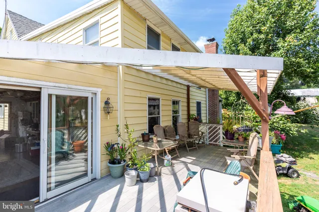 a view of a patio with table and chairs potted plants and floor to ceiling window and potted plants