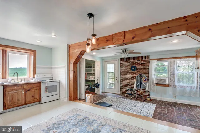a living room with wooden floor and a ceiling fan