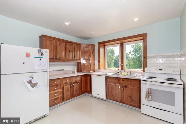 a living room with stainless steel appliances kitchen island granite countertop furniture and a rug