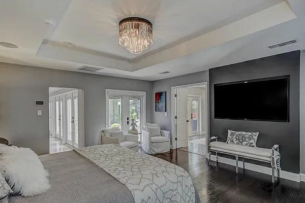 a spacious bedroom with two beds and a chandelier