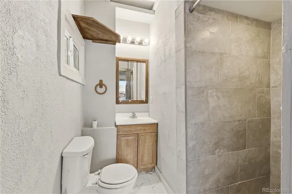 a bathroom with a toilet a sink and shower