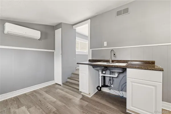 a kitchen with a sink cabinets and wooden floor