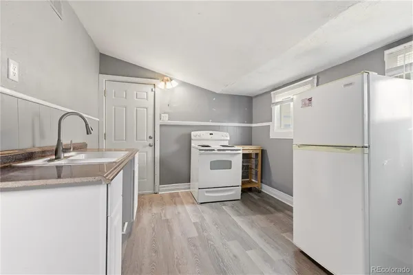a kitchen with a refrigerator sink stove and cabinets