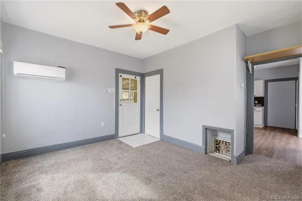 an empty room with windows and a ceiling fan