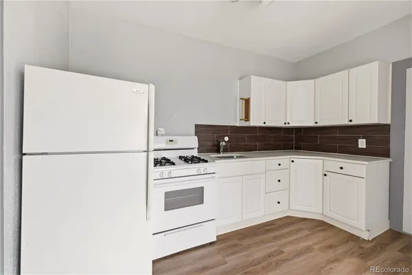 a kitchen with cabinets appliances and wooden floor